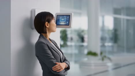 businesswoman interacts with a smart wall-mounted display in a modern office