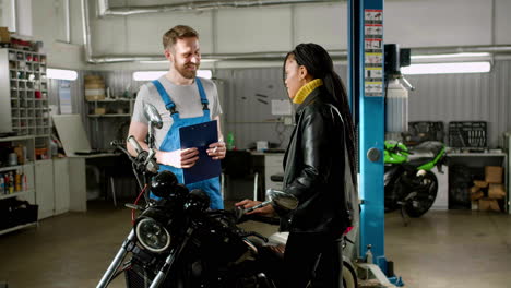 mechanic and rider talking at the garage