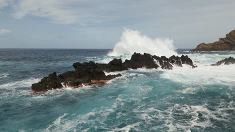 spectacular ocean waves splash on volcanic rocks on madeira coast, aerial