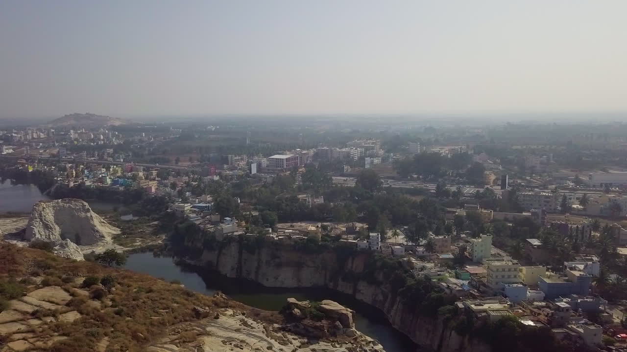vista aérea de una ciudad situada en una cantera de piedra al lado de un lago en hyderabad, india durante el día