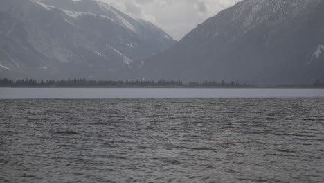 vista diurna del lago en lagos gemelos con montañas nevadas en el fondo y olas visibles del lago