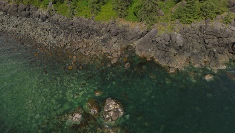 pedestal drone shot over rocky coastal area near sandpit, grey bay, canada