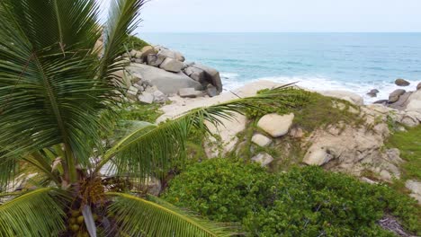 Rocky-Coastline-at-Tayrona-Beach-in-Santa-Marta,-Colombia-in-aerial-reveal-shot