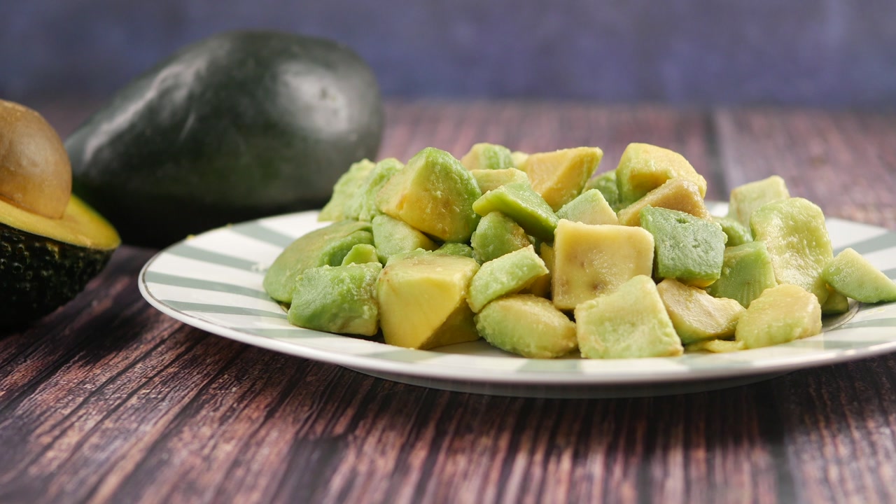 Fresh Diced Avocado on a Plate with Whole Avocados