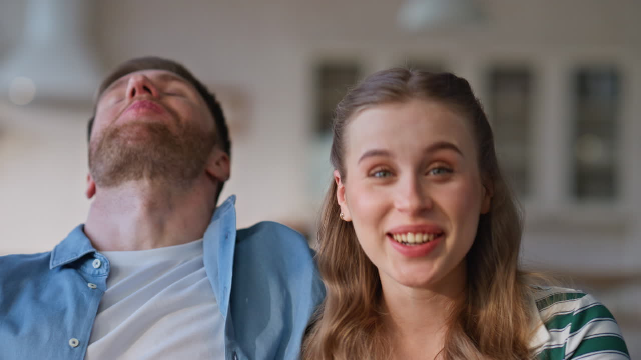 Couple hands taking popcorn from glass bowl at home closeup. Lovers watching tv