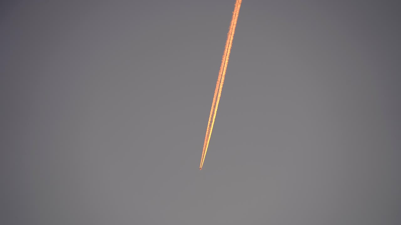 plane taken from the ground leaving a trail of pink clouds international flight