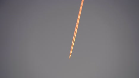 plane taken from the ground leaving a trail of pink clouds international flight