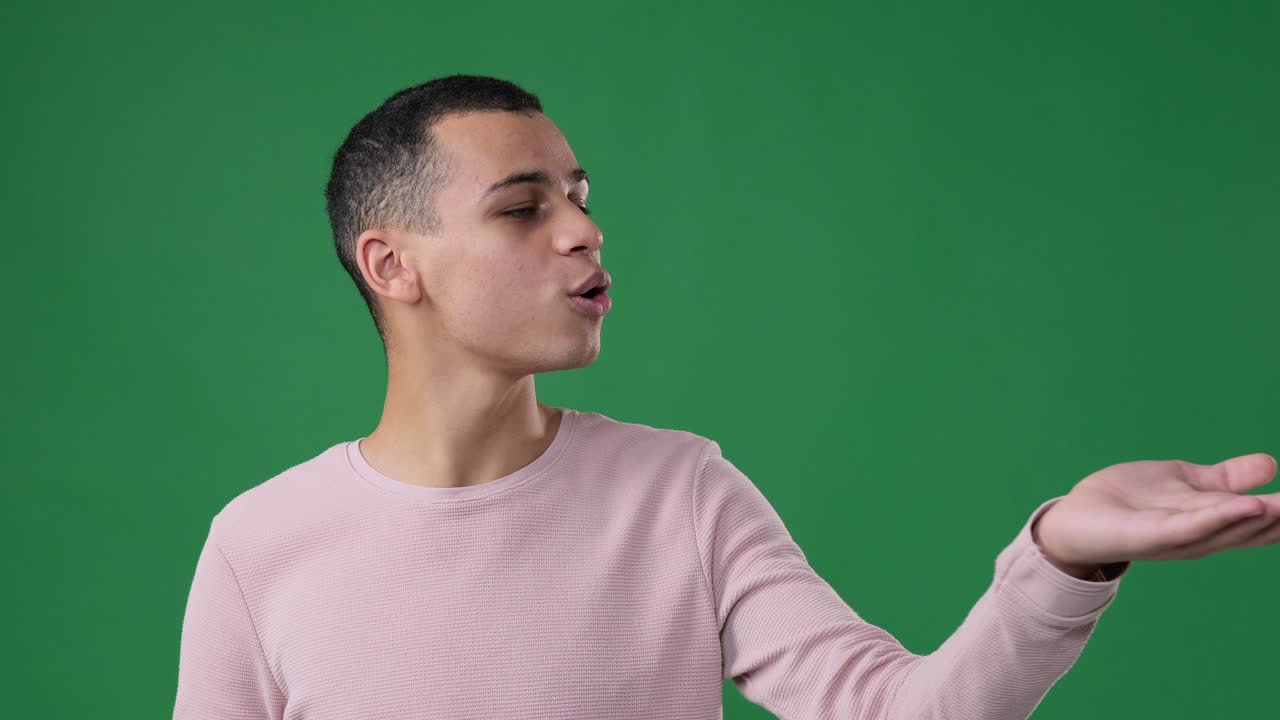 Man giving flying kisses over green background
