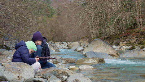 siblings enjoying a walk by a mountain river