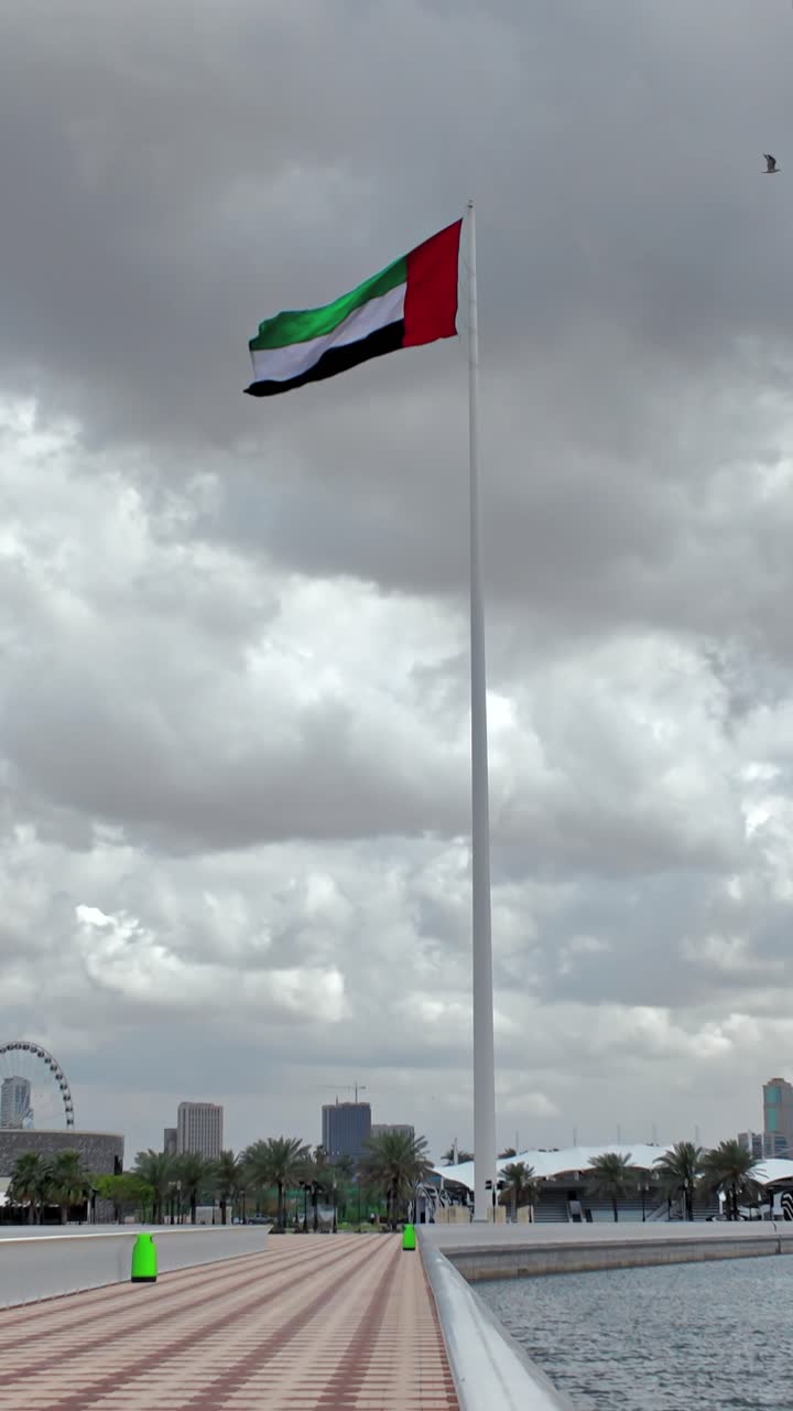 Cảnh quốc kỳ UAE đang bay trên Sharjah vào một ngày nhiều mây.
