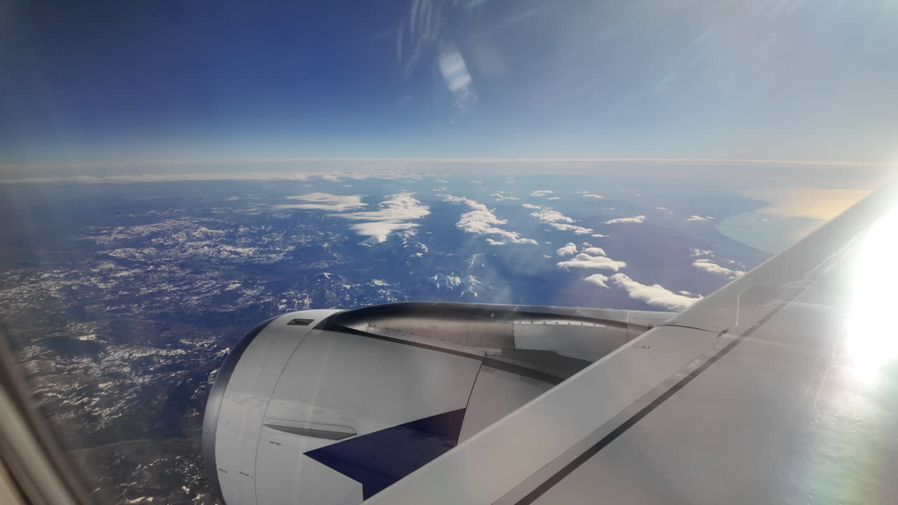 Vista da un finestrino di un aereo su una catena montuosa e il mare