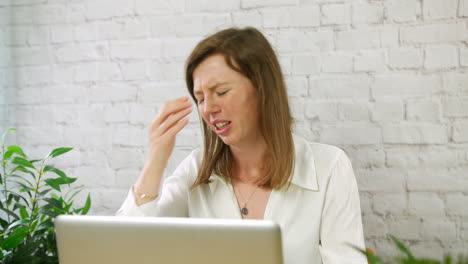 An-upset-and-stressed-young-woman-student-looking-at-a-stack-of-paperwork-and-bills-and-throwing-them-in-the-air