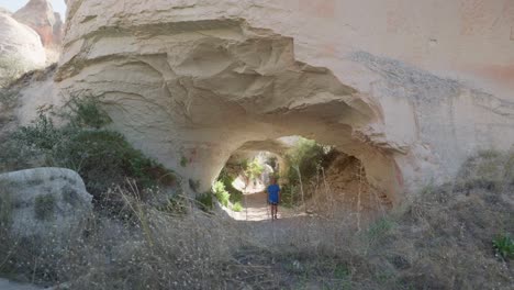 weibliche wandererin erkundet die natürliche felshöhle red valley trail cappadoccia