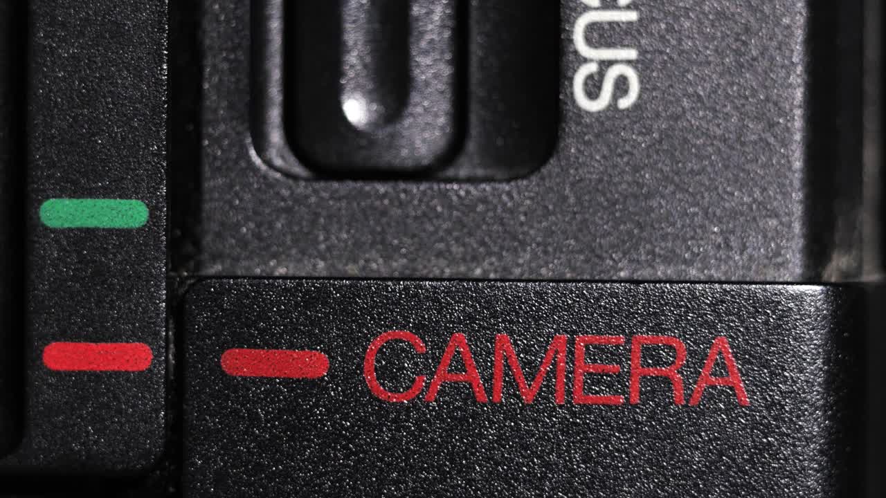 Close up of black camcorder slider moving from green play to red camera mode