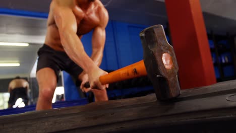 hombre haciendo un ejercicio de entrenamiento con martillo