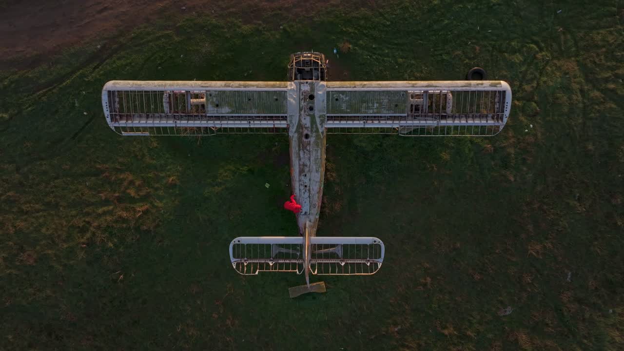 Des ruines d'un vieil avion reposent dans un paysage verdoyant à l'heure dorée, Bulgarie