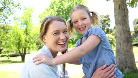 Niña-Feliz-Contándole-Un-Secreto-A-Su-Madre-En-El-Parque