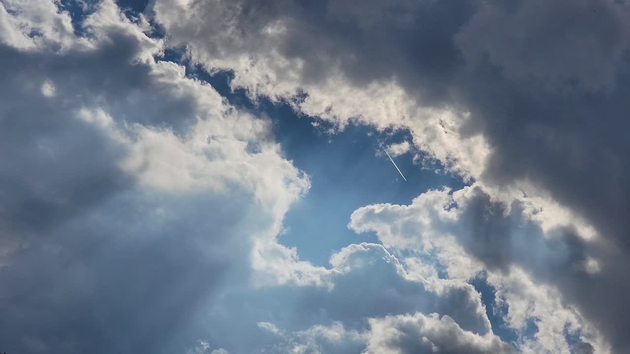The sky is illuminated by dramatic lights that are shining through the clouds