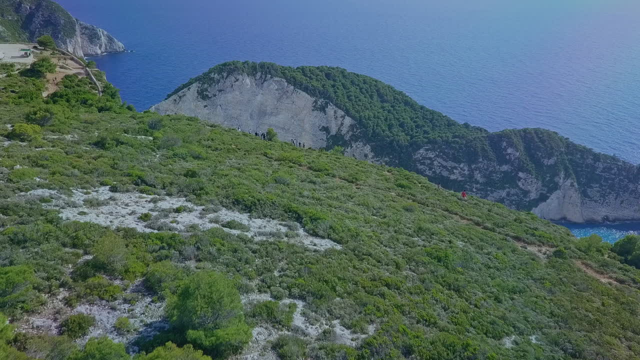 나 바지오 난파선 코브가 내려다 보이는 절벽 위의 사람들을 공중으로 통과