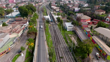 city light rail arriving at an open-air subway station in a south american city