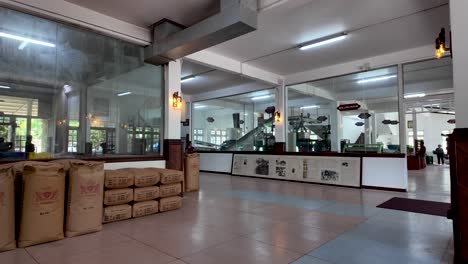 an interior shot of a tea processing factory in sri lanka, showcasing tea sacks and machinery in a spacious, well-lit processing room.