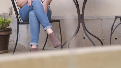 Close-up-slide-shot-of-a-fountain-with-a-woman-sitting-at-a-table-in-the-background