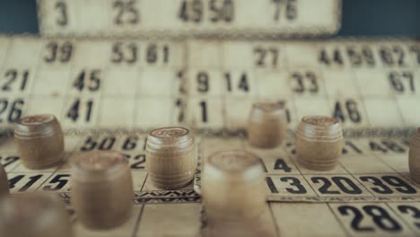 Macro-video-of-a-Bingo-board,-studio-lights,-120-fps,-slow-motion,-wooden-chip-digits,-Raw-footage,-lottery-desk-game,-card-numbers,-crane-zoom-in-smooth-movement