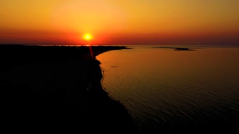 4k uhd aerial drone view beautiful sunset over tropical beach with clouds in the middle of the sea