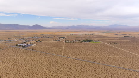 Toma-De-Reenvío-De-Vista-Aérea-De-Una-Ciudad-Del-Desierto-Con-Una-Carretera-Que-La-Atraviesa