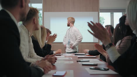 specialists and managers are cheering male expert after his performance in business meeting