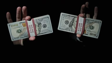 dos pilas de 10000 dólares estadounidenses paquetes en manos masculinas en fondo negro