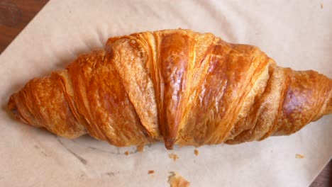 close up of a golden brown croissant on parchment paper