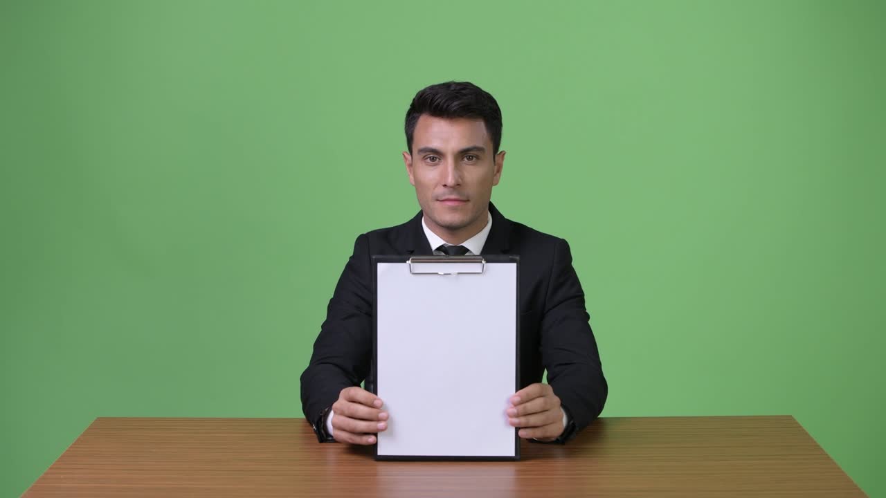 초록색 배경에 젊은 잘생긴 히스패닉 사업가