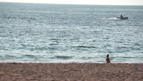 mujer buscando un barco en una playa de portugal.