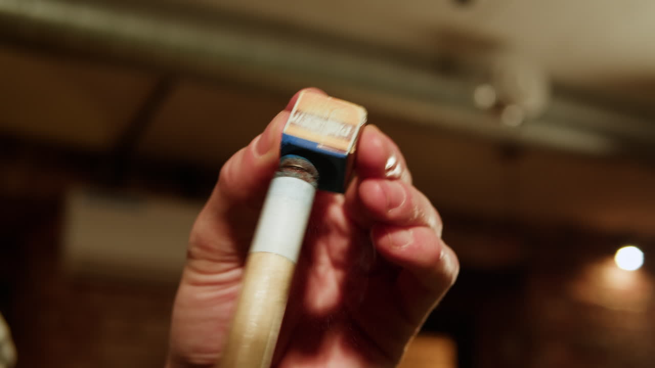 aplicación de tiza en el taco de billar