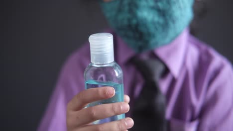 child wearing mask and holding hand sanitizer