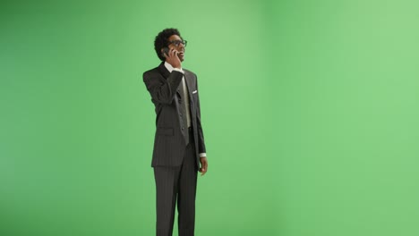 businessman receives good news on phone with green screen