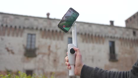 un hombre europeo demuestra las características del nuevo estabilizador gimbal de la cámara móvil insta360 flow