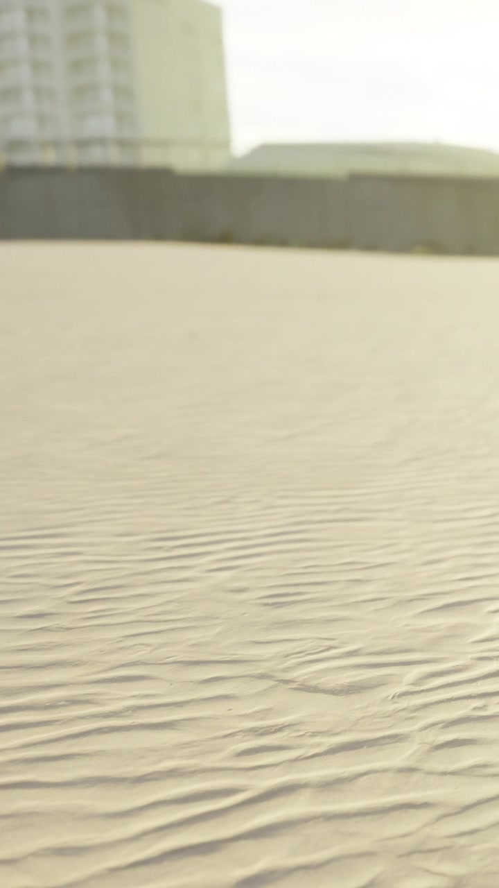 Soft waves of sand stretch across a large desert area near a city