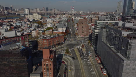 Aerial-ascending-view-of-low-traffic-in-urban-neighbourhood.-Street-and-crossroads-surrounded-by-apartment-buildings.-Queens,-New-York-City,-USA