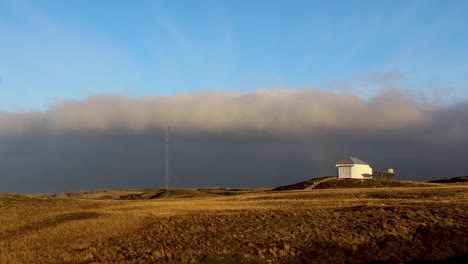 time laps of clouds moving past a old steel lab situated on top a hill