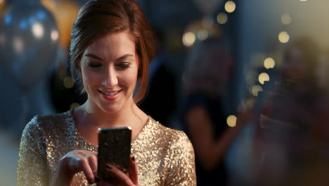 woman at a party using a smartphone