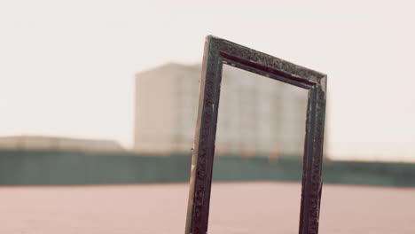 empty ornate frame on pink floor with city background