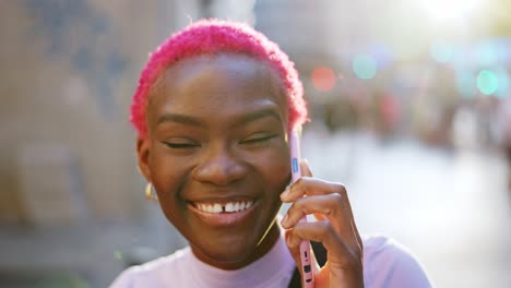 young person with vibrant pink hair talking on a smartphone outdoors