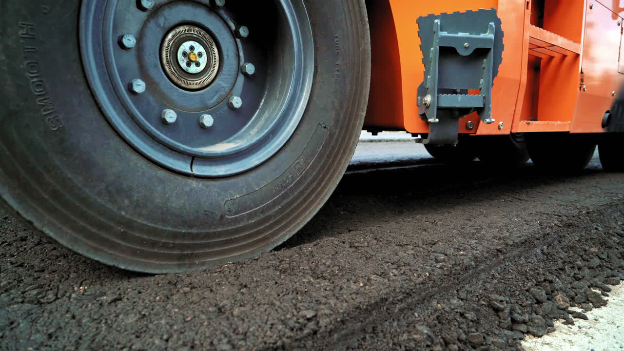 New asphalt road under construction. Asphalting construction works with commercial repair equipment