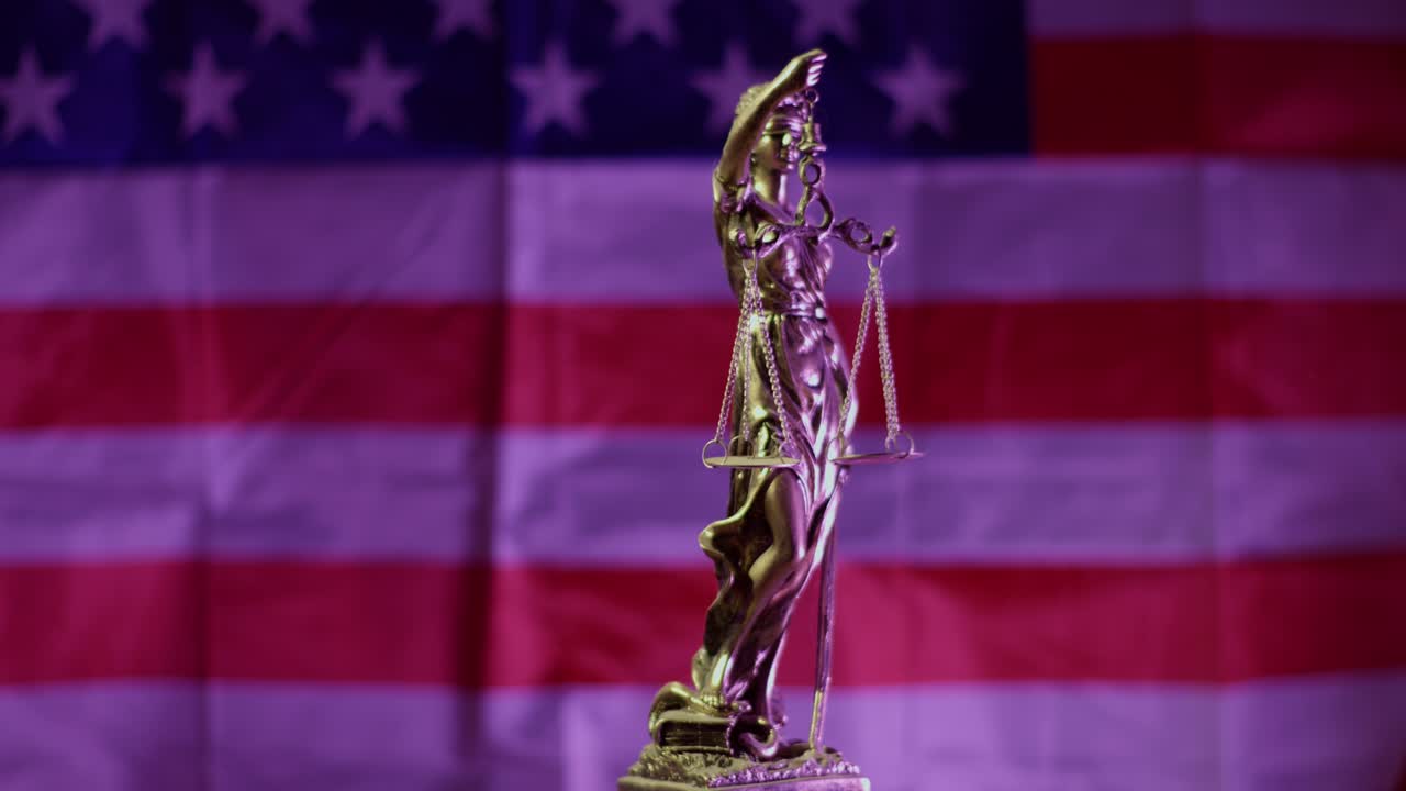 Statua della Giustizia in rotazione sullo sfondo della bandiera americana