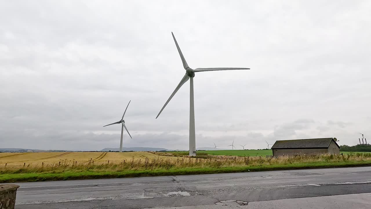 시골 건물 근처에서 회전하는 풍력 터빈