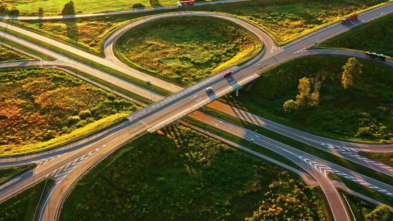 Aerial view of Cloverleaf interchange with long road shadows during golden hour sunrise