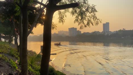 Riverboat-Going-Past-Against-Golden-Orange-Yellow-Sunset-Skies-In-Dhaka