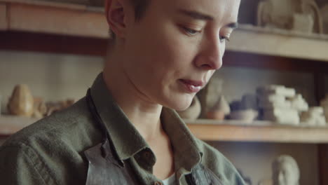 female sculptor working with clay and taking break